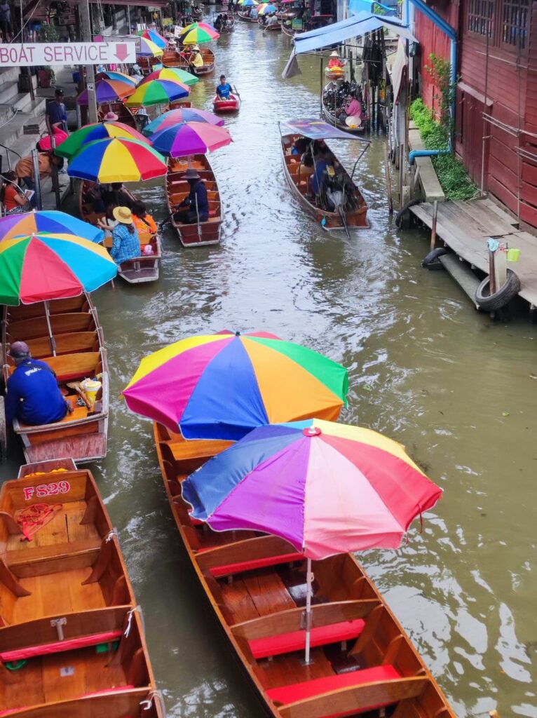 Colourful umbrellas on boat in waterway at Damnoen Saduak Floating Market.